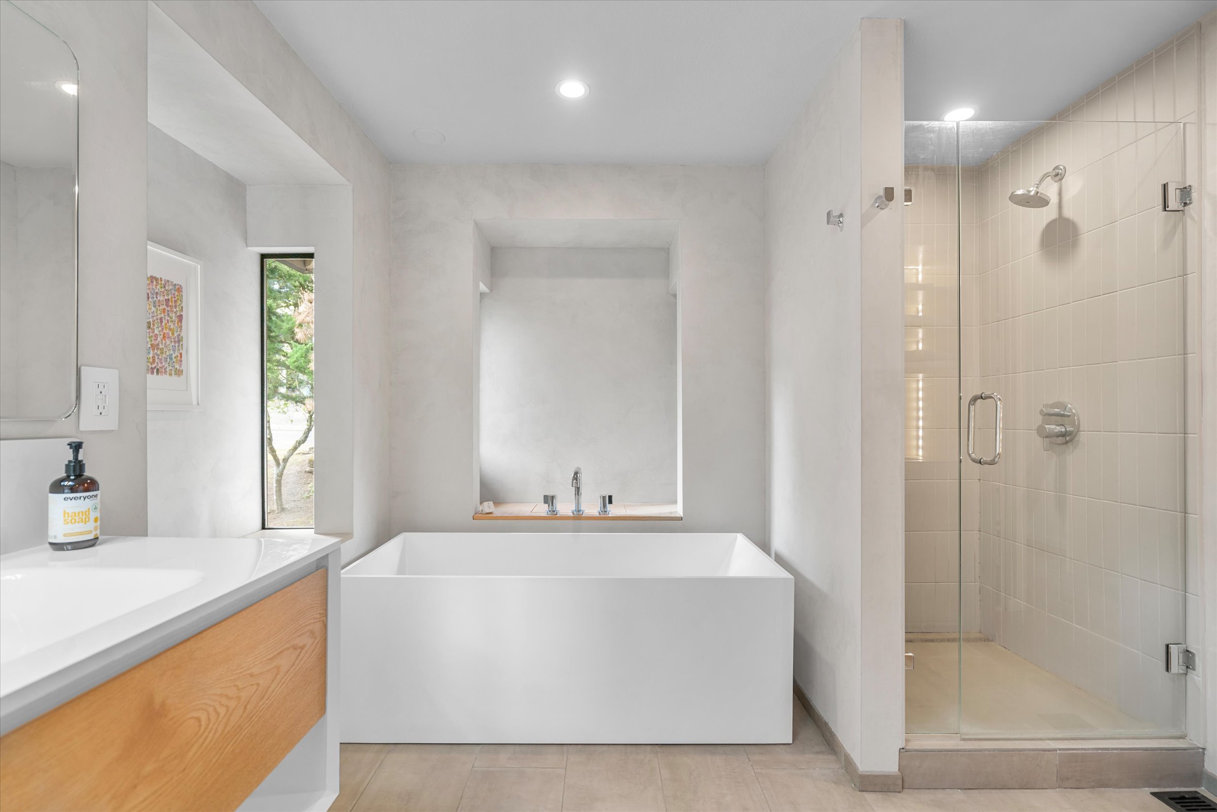 The master bathroom — soaking tub in niche, floating oak vanity